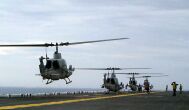 Image: Crew members aboard the USS Wasp hot refuel an AH-1W Super Cobra.